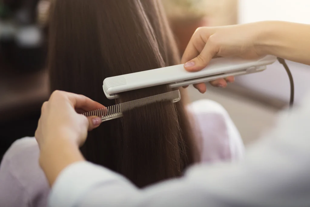 hairdresser-straightening-combing-long-brown-hair-professional-beauty-salon
